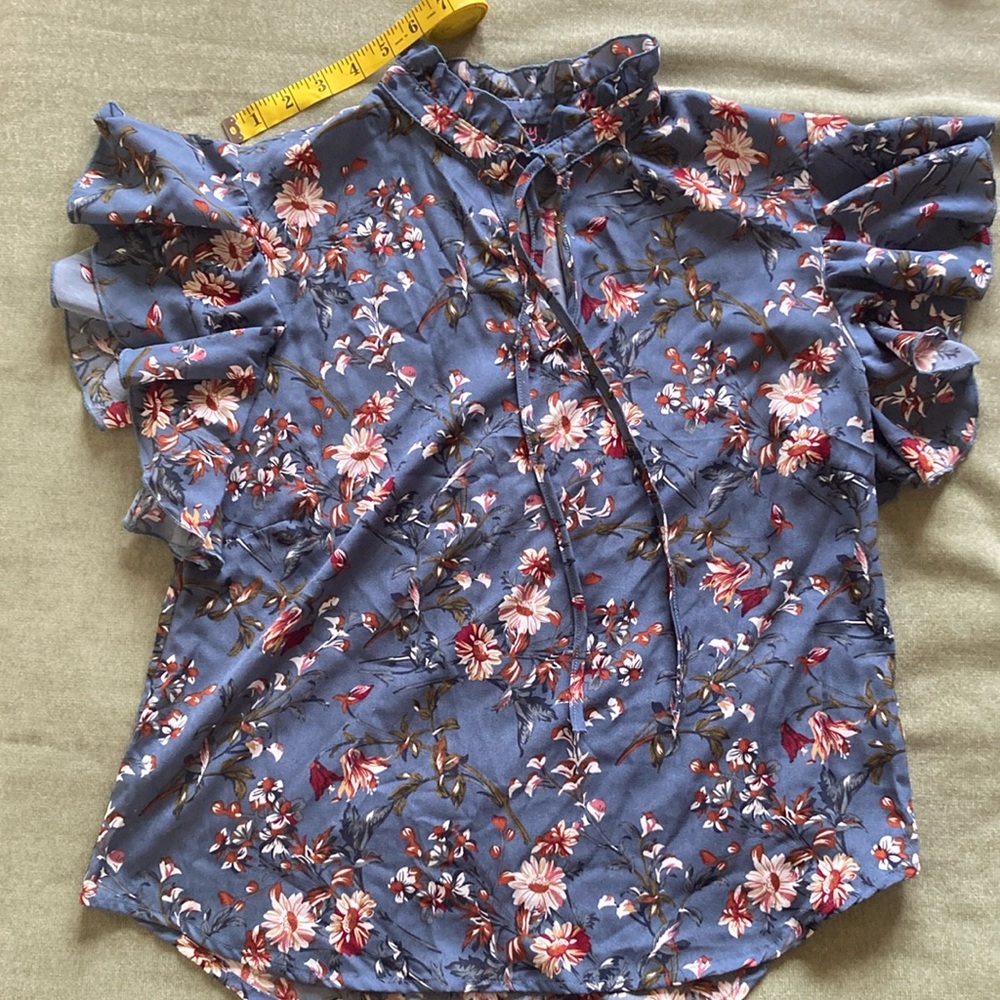 NWOT Lipsy medium grey blue flowered top. Never worn. Ruffled sleeves.